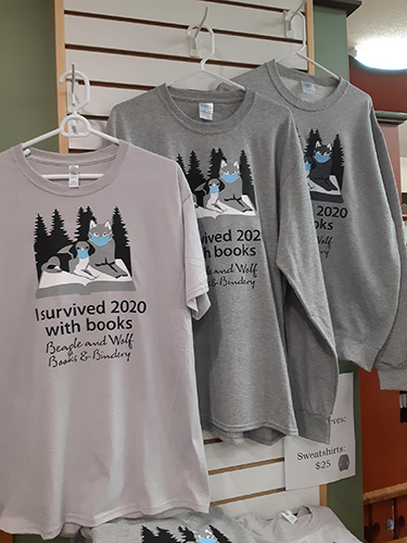 Shirts with "I survived 2020 with books" and the Beagle and Wolf logo including masks on the mascots